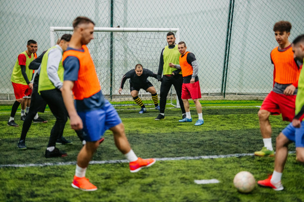 在球门处踢球的足球运动员图片下载