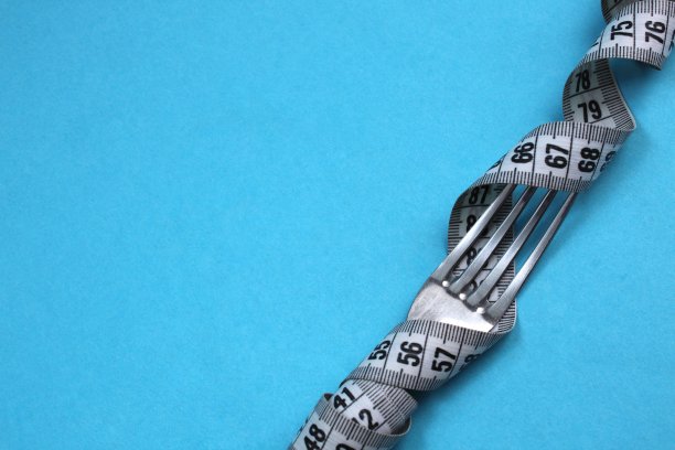 厘米磁带扭曲在一个叉在蓝色背景上图片下载