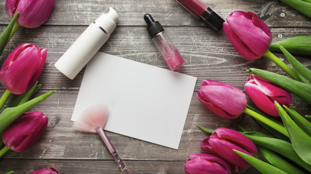 女性办公桌工作空间与化妆品，口红和郁金香花木制背景。平躺，俯视图图片下载