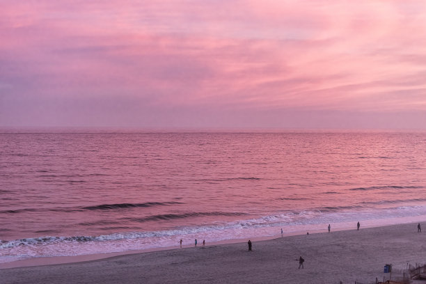 默特尔海滩与空中高角度的观点在大西洋日落黄昏与彩色的粉红色阳光在水平线反射和人们在沙滩上图片下载