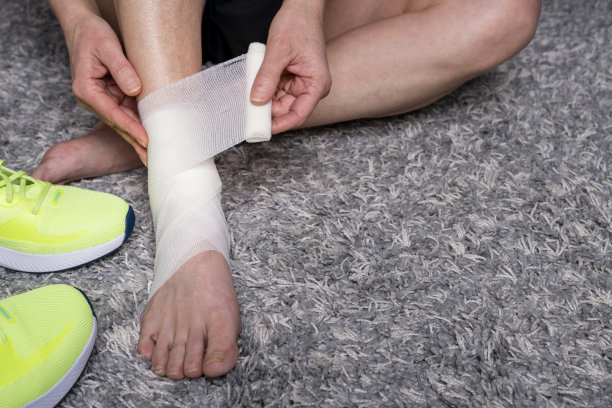 一名妇女自己包扎受伤的脚踝图片下载