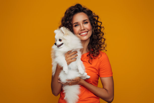 微笑的小女孩抱着小狗的工作室肖像图片下载