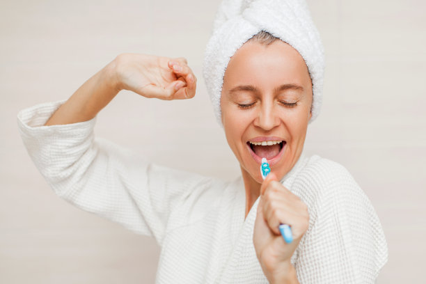 站在浴室室内用牙刷刷牙的快乐女士图片下载