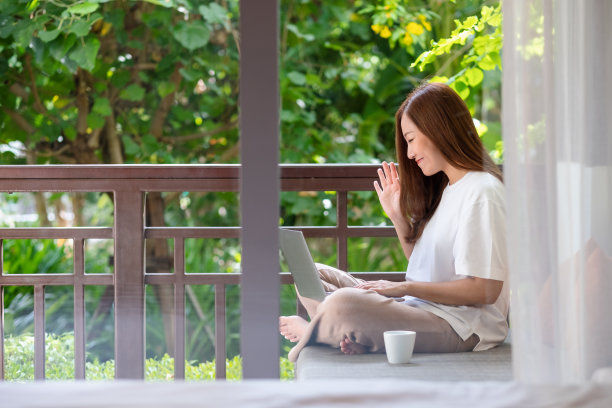 一个年轻女人使用笔记本电脑视频电话和工作在家里的肖像图像图片下载