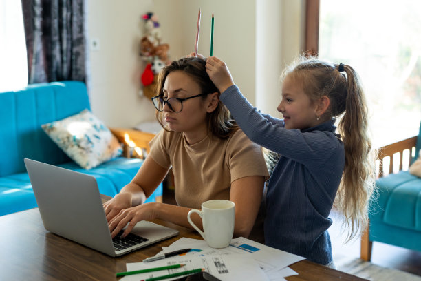 疲惫的年轻母亲用笔记本电脑工作，而孩子玩得很开心，制造噪音图片下载