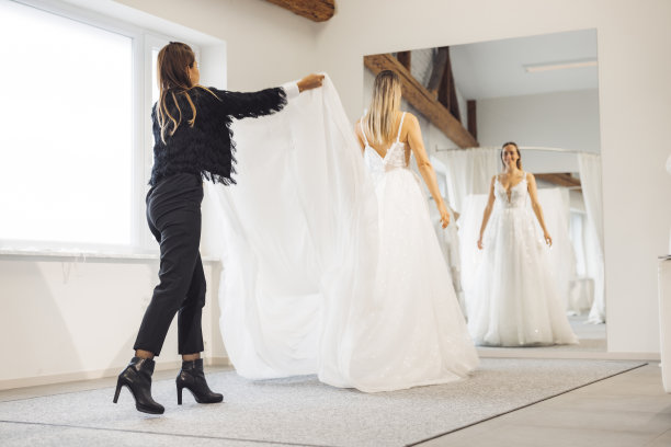 婚礼精品店老板帮助新娘找到合适的婚纱图片下载