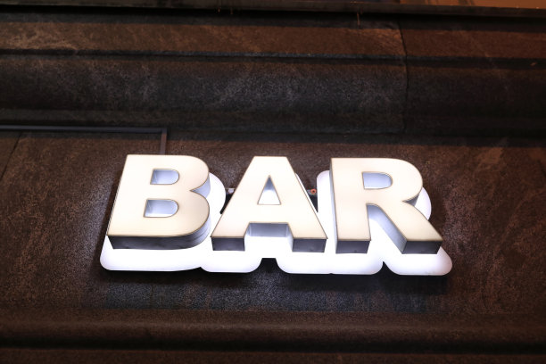 夜间建筑物墙上的酒吧招牌图片下载