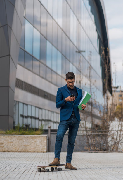 年轻律师用智能手机玩滑板图片下载