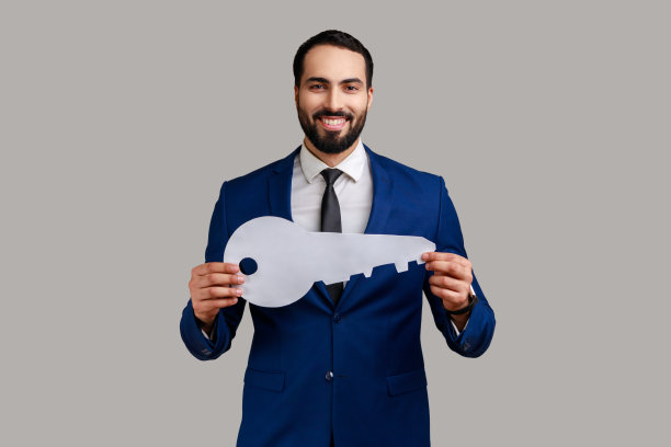 男人手里拿着大纸钥匙，露出露齿的微笑看着镜头，自己住图片下载