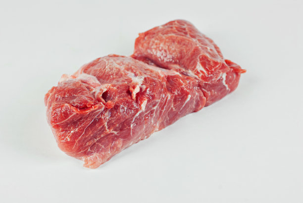 红肉接近。一块白色背景的猪肉。准备肉类菜肴。图片下载