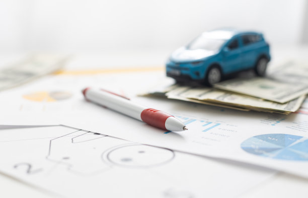 图纸背景上的小玩具车和木制玩具房子的特写图像。图片下载