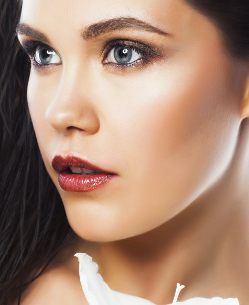 年轻漂亮的女人用大白花封闭孤立在白花上，手部修指甲，水疗人的概念图片下载