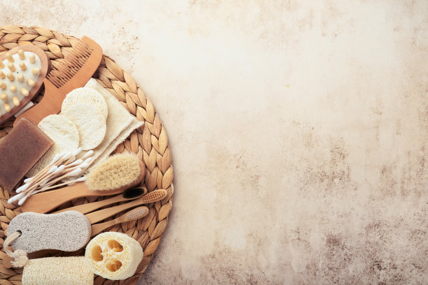 “零浪费”的概念。一套生态友好的浴室配件在沙色混凝土米色背景与深阴影。环保和再利用的理念。前视图。图片下载