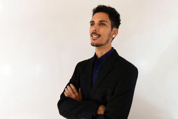 一个穿着社交t恤的黑人在工作室里被黄色的背景孤立起来。孤立的商人，充满戏剧性的光芒。图片下载