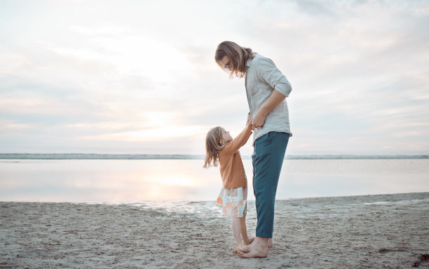 一个男人和他的女儿在海边共度时光的照片图片下载