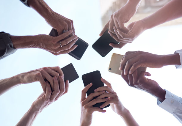 剪裁拍摄的一群不认识的商人使用他们的手机图片下载