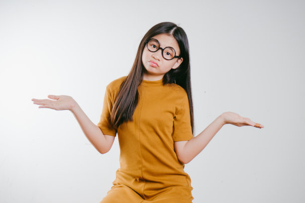 工作室肖像的可爱的年轻亚洲女孩与有趣的脸。图片下载