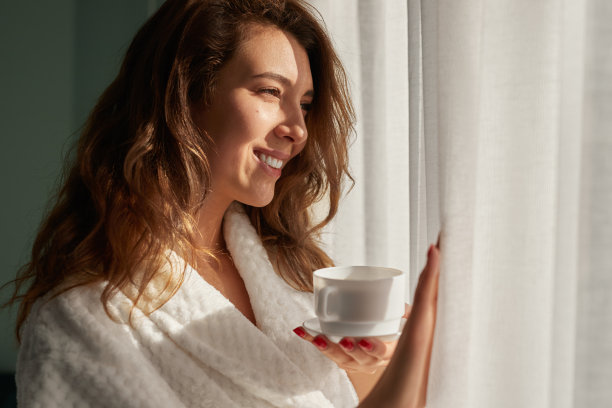 喝着咖啡看着窗户的快乐女人图片下载