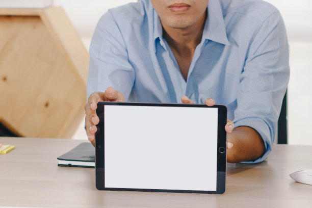年轻的亚洲男子拿着一个空白的平板电脑。图片下载