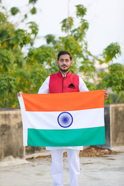 年轻的印度男子站在印度国旗的自然背景下。图片下载