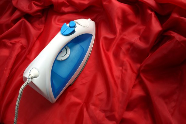 白热熨烫烫起皱的红色织物图片下载