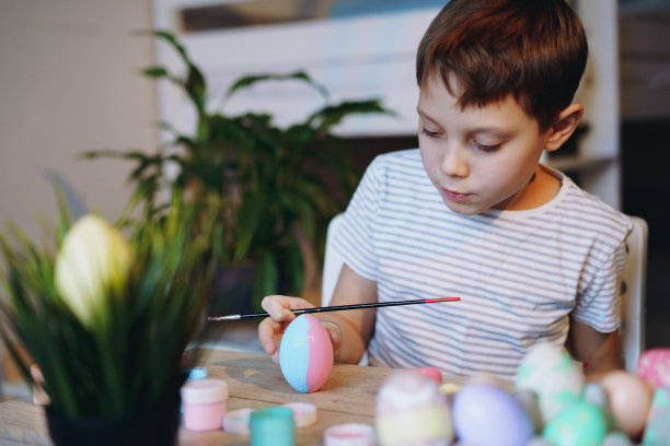 可爱的小男孩在复活节上彩蛋图片下载