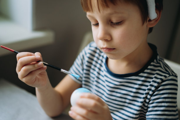 可爱的小男孩在复活节上彩蛋图片下载