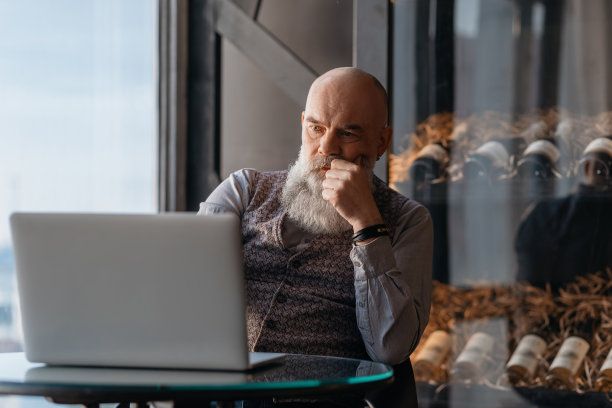 上了年纪的酒店老板正在用笔记本电脑工作图片下载