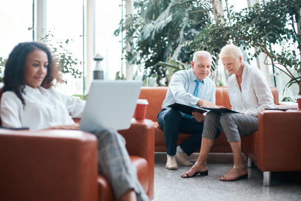 商人和女商人在办公室大厅里互相握手致意图片下载