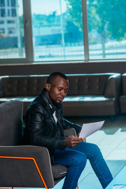 一位非洲裔美国商人坐在现代办公室里与同事讨论一个项目的肖像图片下载