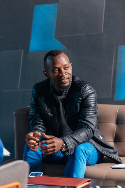 一位非洲裔美国商人坐在现代办公室里与同事讨论一个项目的肖像图片下载