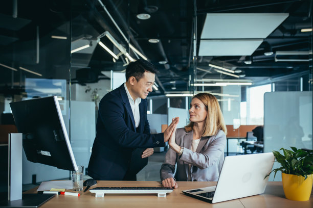 一男一女是上班族，在办公室里工作，为成功而欢欣鼓舞，一起拍手图片下载