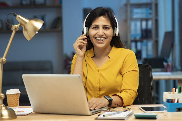 呼叫中心女话务员戴着耳机与客户通话，库存照片图片下载