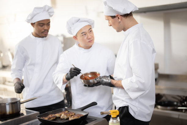 厨师在厨房里用勺子品尝酱汁图片下载