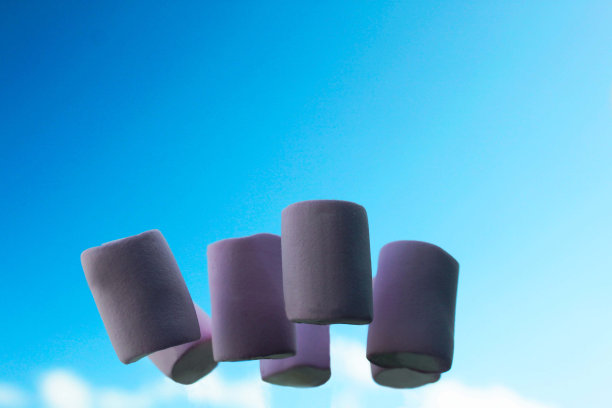 几片粉红色的棉花糖在蓝天和白云的背景上图片下载