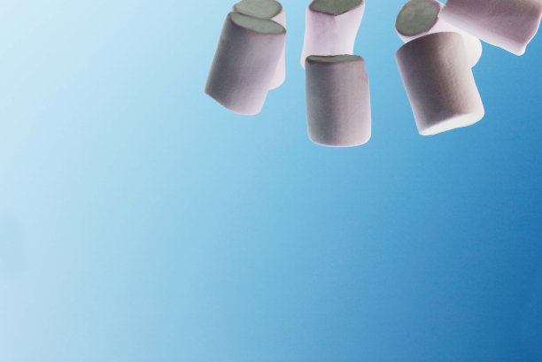 几片粉红色的棉花糖在蓝天和白云的背景上图片下载