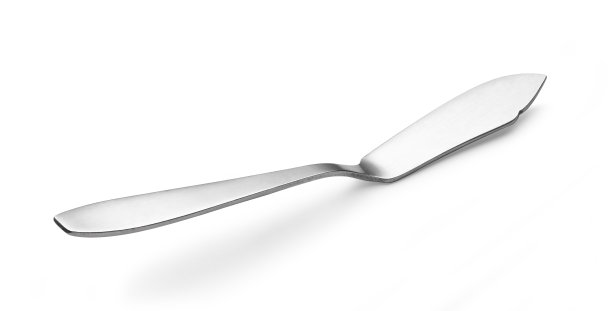 刀子把黄油和果酱涂在白色的底色上。图片下载