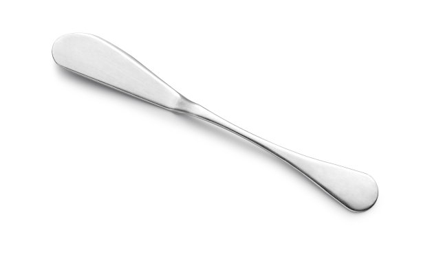 刀子把黄油和果酱涂在白色的底色上。图片下载