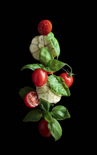 黑色背景上的番茄、罗勒和大蒜。图片下载