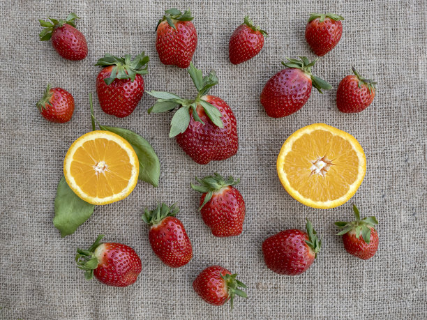 把草莓和橘子平铺在粗麻布上图片下载