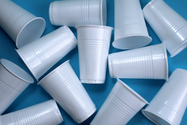 一堆塑料杯躺在蓝色的背景上。图片下载