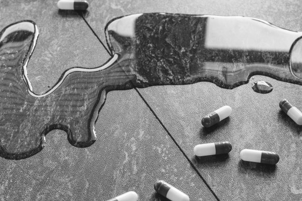 平板电脑。从手上滴下药丸和一杯水。图片下载