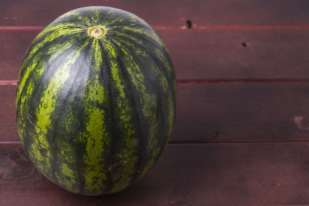 美丽的西瓜孤立在木制背景上。健康食品的概念。图片下载
