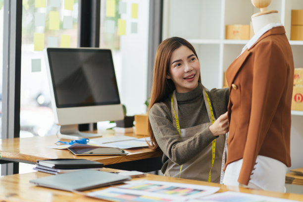 有吸引力的亚洲女性时装设计师在家庭办公室工作间工作。时尚时尚女性创造新的布料设计收藏。裁缝和缝纫。人们的生活方式和职业观念。图片下载