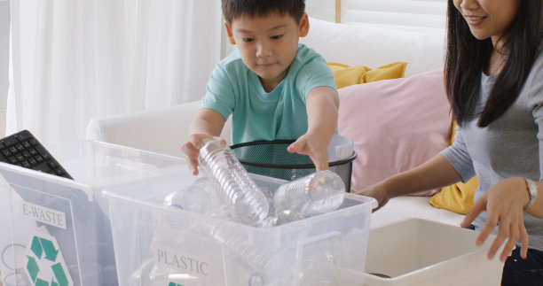 妈妈教Z世代前的男孩小孩丢弃纸玻璃可以电子垃圾袋在再利用垃圾箱循环银行帮助气候变化社会问题在亚洲人民。垃圾分类清洁环保绿色零浪费乐趣在家学习。图片下载