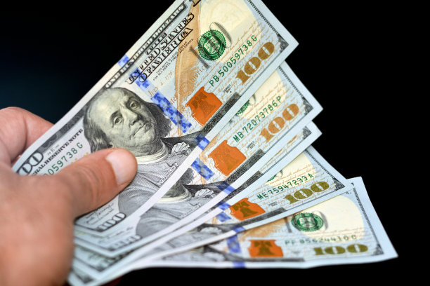 男人手持一叠美元钞票，花费概念图片下载