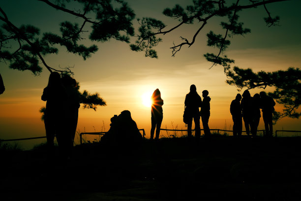 一个女人的剪影和他的朋友在早晨的阳光下拍照。图片下载