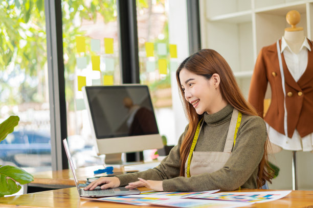 时尚设计师服装设计师站着用彩色的纺织品样品工作。用木偶和彩色织物工作。亚洲女企业家图片下载