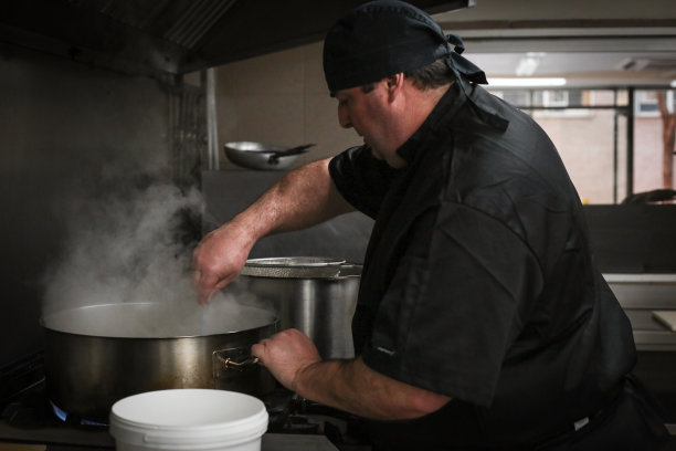 年长厨师和厨师在餐厅准备食物图片下载