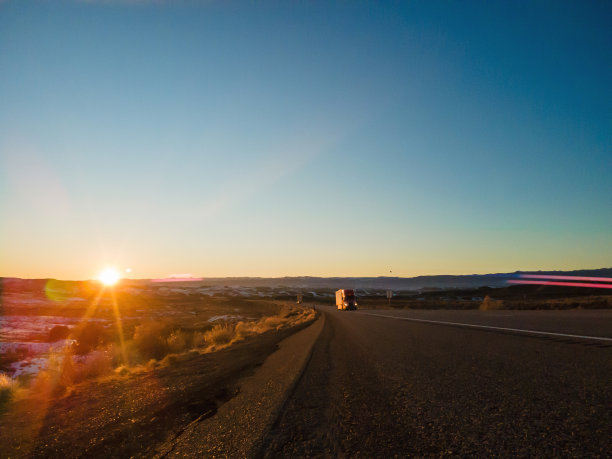 戏剧性的日落货物运输长途运输半挂车和汽车在一个农村西部美国州际公路航空摄影系列图片下载